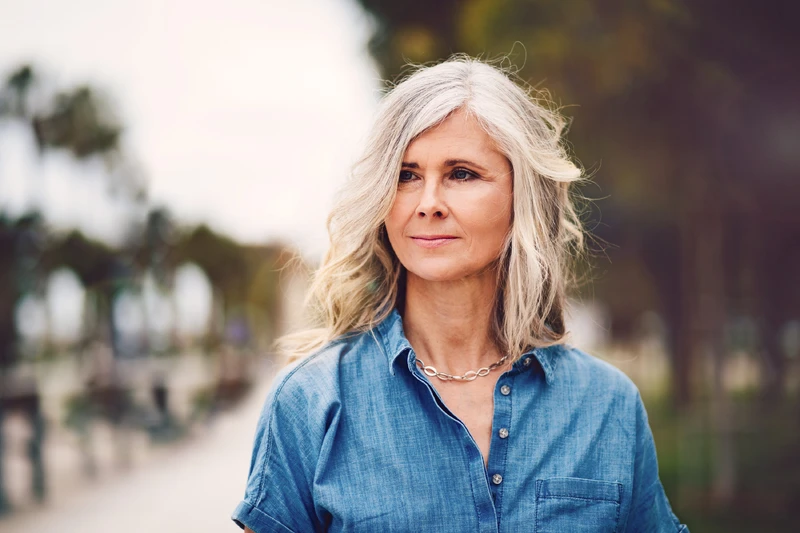 Frau steht draue&szlig;n und schaut in die Ferne